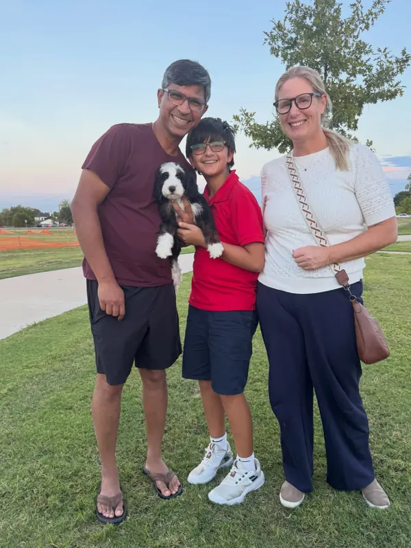 A family on gotcha day, taking home their Bernedoodle puppy from KK Doodles